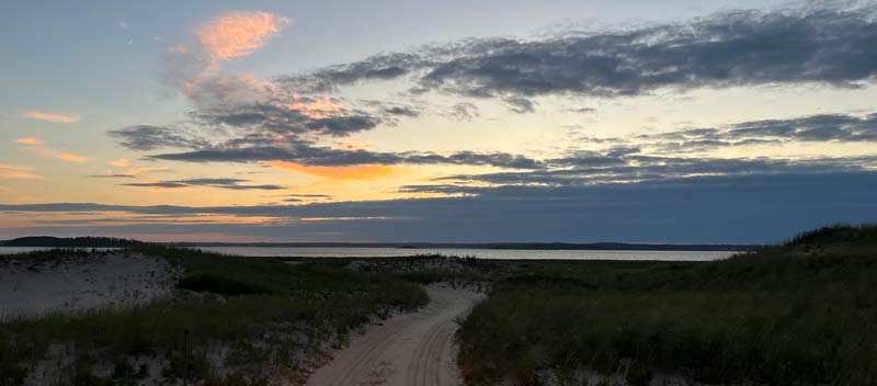 Sunset begins over Pleasant Bay as seen from the backside of Nauset Beach in Orleans.